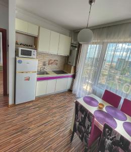 马马亚Sunset Sea View Apartament的一间带桌子的厨房和一间带紫色椅子的厨房
