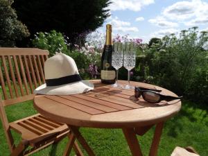 特鲁罗Pengelly Farmhouse B&B的一张野餐桌,配有一瓶葡萄酒和眼镜