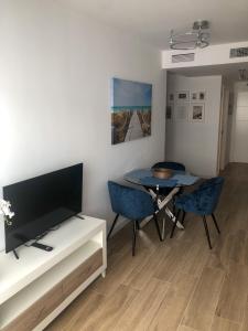 福恩吉罗拉La Rosa Apartment Los Boliches Fuengirola Malaga Spain的客厅配有电视和桌椅