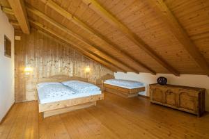 阿维兰奥Ferienwohnung Sonnenblume Nusserhof的配有木天花板的客房内的两张床