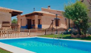 奥萨德蒙铁尔Casas Rurales Lagunas de Ruidera con chimenea的别墅前方设有游泳池