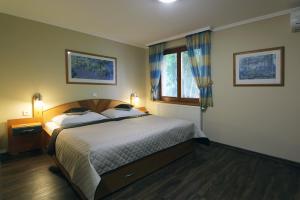 瓦尔季采乌佛库旅馆的一间卧室设有一张大床和一个窗户。
