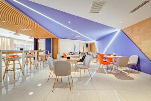 西安西安钟楼智选假日酒店的餐厅拥有蓝色的天花板,配有桌椅