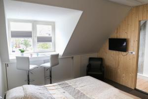 SpakenburgB&B Hartje Spakenburg的一间卧室配有一张床、一张书桌和一个窗户。
