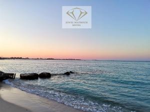 马特鲁港Jewel Matrouh Hotel的日落时从海滩欣赏到海景