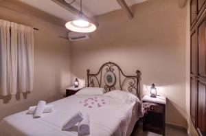 KiónionLikoudis Villas Suites ,on the Kioni,Ionian Islands Ithaca,的一间卧室配有两张带白色床单和两张桌子的床。