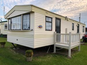 伯克顿Norfolk Poppy Caravan - Sleeps 4 - WiFi and Sky TV Included的白色大篷车,设有门廊和窗户