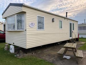 伯克顿Norfolk Lavender Caravan - Sleeps 4 - WiFi and Sky TV Included的一个小房子停在院子里