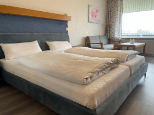 巴特贝德凯萨Seehotel Geestland的一张大床,位于带两张床的房间