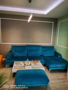 布尔加斯Luxury Apartments Alix的客厅配有蓝色的沙发和桌子