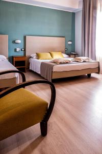 托尔托纳Albergo Cerchi的一间卧室配有两张床和椅子