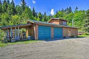 安吉利斯港Picturesque Port Angeles Cabin with Fire Pit!的车道上设有两扇车库门的房子