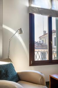 威尼斯MANSARDINA - 1 min from Accademia - duplex stylish and cosy的带沙发和窗户的客厅