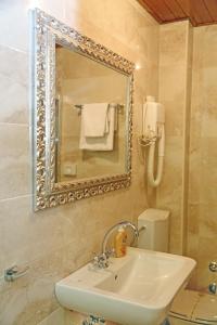 科托尔玛里加酒店的一间带水槽、镜子和卫生间的浴室