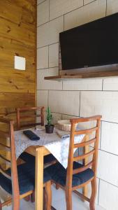 大普拉亚Pousada Vó Ciloca的餐桌、椅子和平面电视