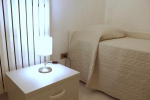 普尔萨诺Villa Bice的一间卧室配有一张床和一张带台灯的桌子