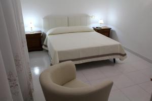 普尔萨诺Villa Bice的一间卧室配有一张床和一把椅子