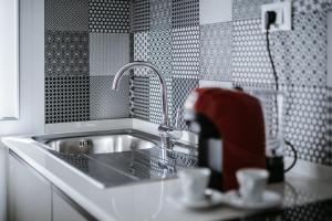 阿布鲁齐的罗塞托L'Anfora Residence的厨房配有水槽和红色搅拌器