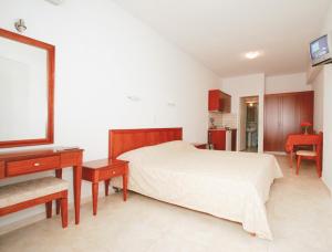 埃亚玛琳娜奈奇多卡里玛拉酒店的一间卧室配有一张床、一张书桌和一台电视
