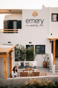 纳克索乔拉Emery Hotel的坐在酒店前方庭院的女人