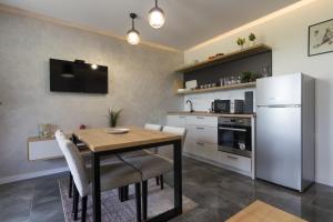 维索科Deluxe Feliciano Apartments的厨房配有木桌和冰箱。