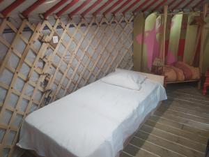 坎佩尔Ravissant yourte traditionnelle的一间带一张白色床的卧室,卧室位于带冲浪板的房间内