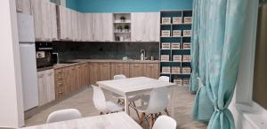 德瓦HOSTEL CITADELLA的厨房配有白色的桌子和白色的椅子