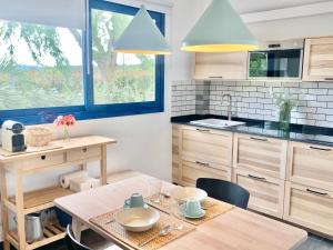 布拉内斯Villa Nature con Piscina Privada · Wifi ·AC · BBQ的一间带桌椅的厨房和一间蓝色调的厨房