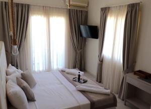 尼亚埃普伊达夫罗斯marilena的卧室设有一张带窗户的白色大床