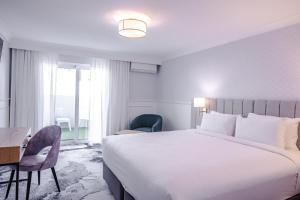 卧龙岗托拉吉海滩康福特茵酒店的酒店客房设有一张大床和一张书桌。