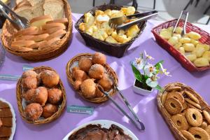 伊帕廷加Vinds Economic Hotel的紫色桌子,上面有食物和面包篮