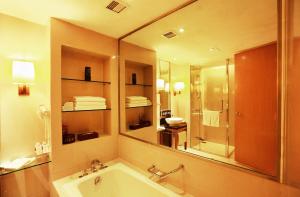 南京Jinling Resort Nanjing的一间带浴缸和大镜子的浴室
