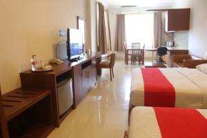茂物HOTEL & WISMA BINTANG JADAYAT的酒店客房设有两张床和一张书桌及电视
