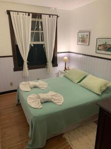 彼得罗波利斯Fachoalto Budget的一间卧室配有绿床和毛巾