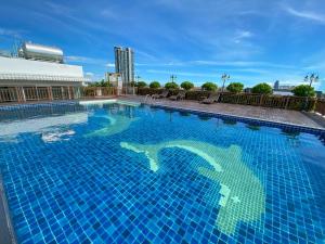 北芭堤雅Vareena palace hotel的一座大型蓝色游泳池,位于一座建筑的顶部