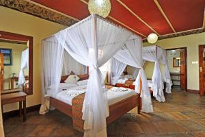 奈瓦沙Mwanzo Lodge的卧室配有2张带白色窗帘的床