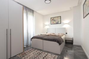 维索科Deluxe Feliciano Apartments的白色的卧室设有床和窗户