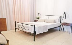 Míloi斯塔维斯旅馆的一间卧室配有带白色床单和枕头的床。