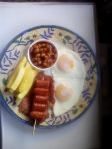 阿曼济姆托蒂Birdcage B&B的包括鸡蛋豆和水果的早餐食品