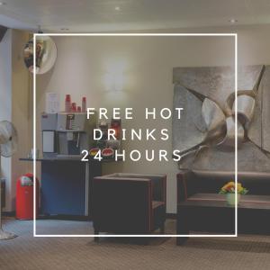 温特图尔Hotel Wartmann am Bahnhof的表示在客房内享用免费热饮的标志