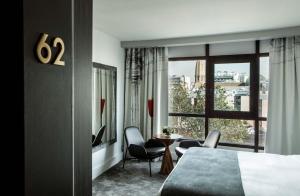 巴黎帕里斯巴黎埃菲尔铁塔酒店的酒店客房带床、椅子和窗户