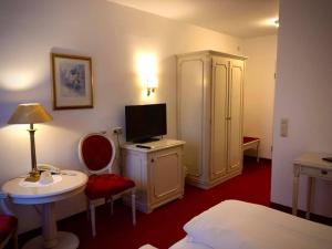 哈尔伯格摩斯丹尼尔斯酒店的酒店客房配有一张床和一张书桌及一台电视