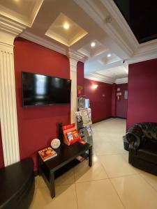 喀山多瑙河酒店的客厅设有红色的墙壁、一张沙发和一张桌子