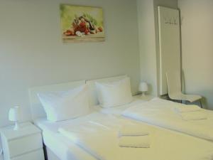 柏林BNB Potsdamer Platz - Rooms & Apartments的一张白色的床,配有白色枕头,墙上挂着一张照片