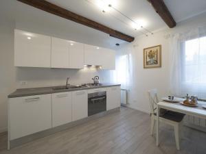 威尼斯SS吉奥瓦尼鲍罗公寓的厨房配有白色橱柜、桌子和水槽。