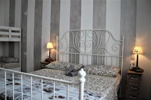 贝加莫Rial Maison的一间卧室配有一张带床头板的床和两盏灯。