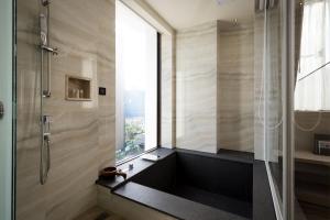 礁溪幸福之乡温泉旅馆 的带淋浴的浴室和窗户。
