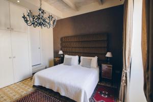 森格莱阿森格莱阿萨利港酒店的卧室配有白色的床和吊灯。