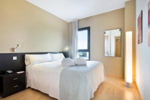 马德里Madrid Airport Suites, Affiliated by Meliá的卧室设有一张白色大床和一扇窗户。