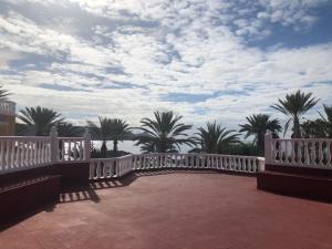 美洲海滩Apartamento Las Vistas Beach - Tenerife Royal Gardens的棕榈树和云天的白色桥梁